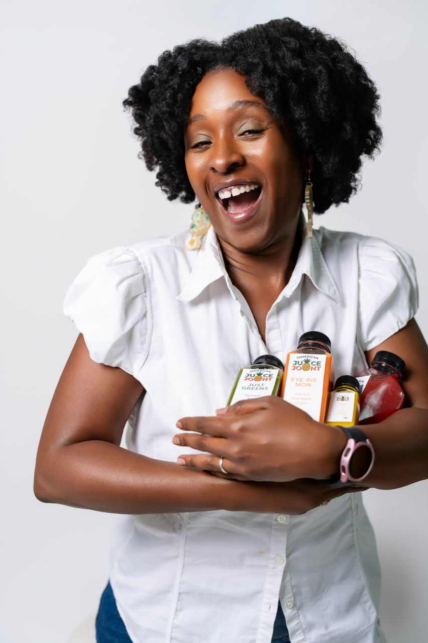 Jamerican Juice Joint founder holding fresh juices